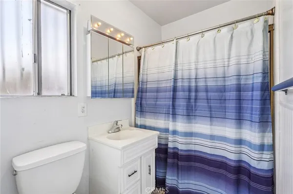 a bathroom with a sink a toilet and shower curtain