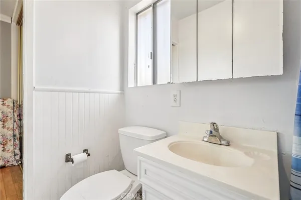 a bathroom with a toilet a sink and mirror