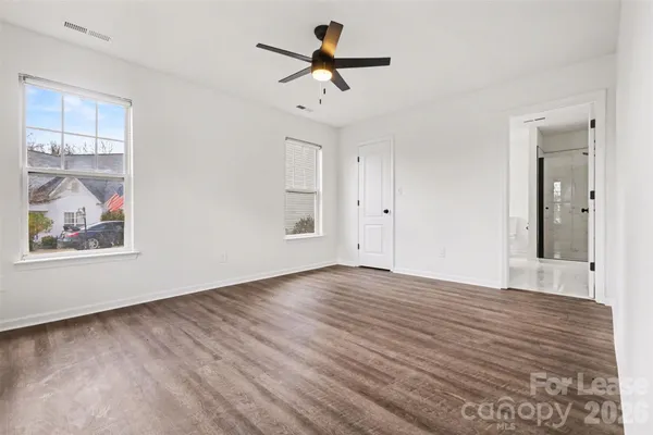 a view of a room with wooden floor and a ceiling fan