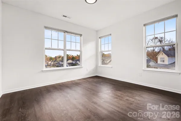 an empty room with wooden floor and window