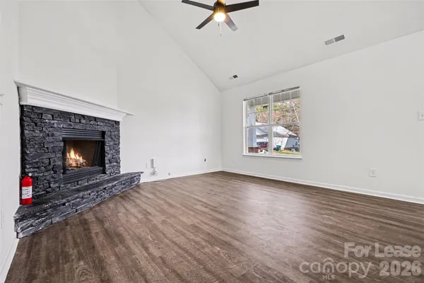 an empty room with windows and fireplace