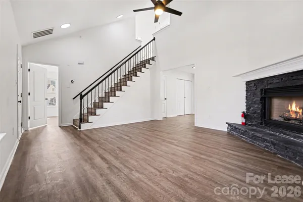 a view of empty room with fireplace and wooden floor
