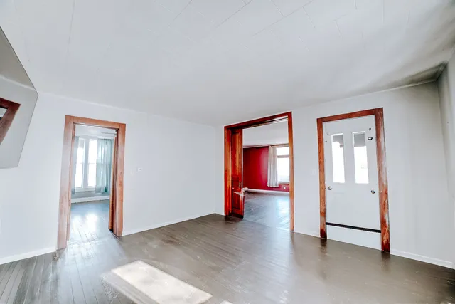 an empty room with wooden floor and mirror