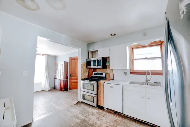 a kitchen with stainless steel appliances a stove a sink and a refrigerator