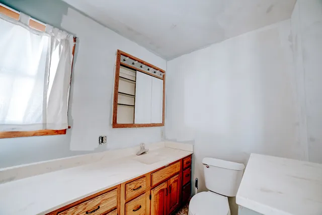 a bathroom with a toilet sink and mirror