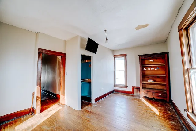 a view of an empty room with closet and a window