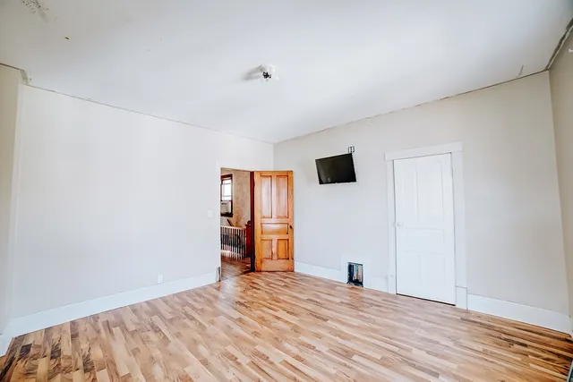 a view of empty room with wooden floor