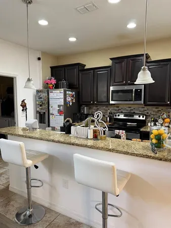 a kitchen with stainless steel appliances granite countertop a sink a stove and a refrigerator