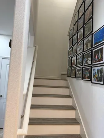 a view of a hallway and an empty room with wooden floor