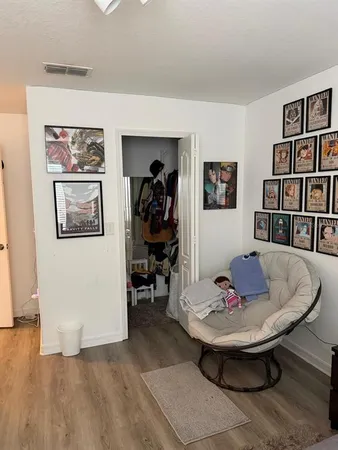 a living room with wooden floor and flat screen tv
