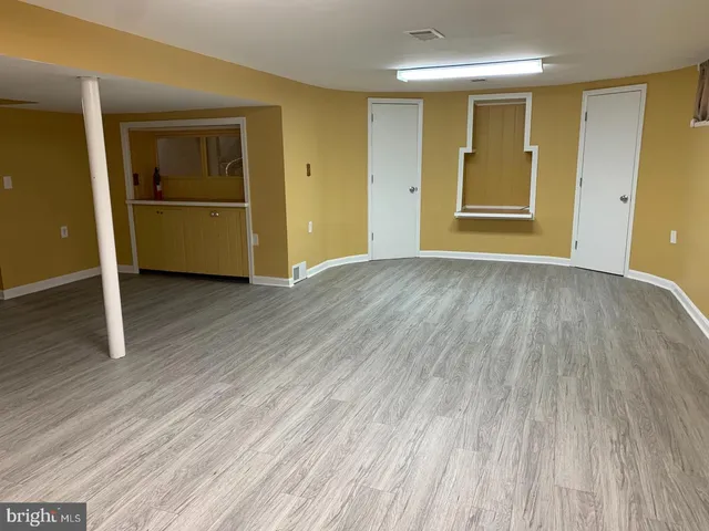 an empty room with wooden floor and closet