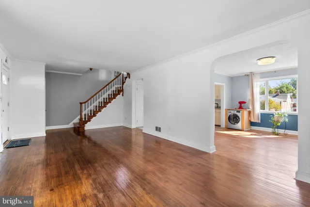a view of a livingroom with wooden floor and stairs