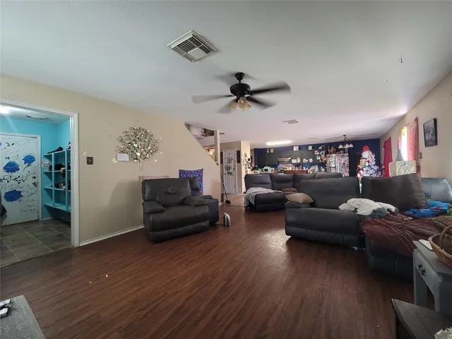 a living room with furniture and a wooden floor