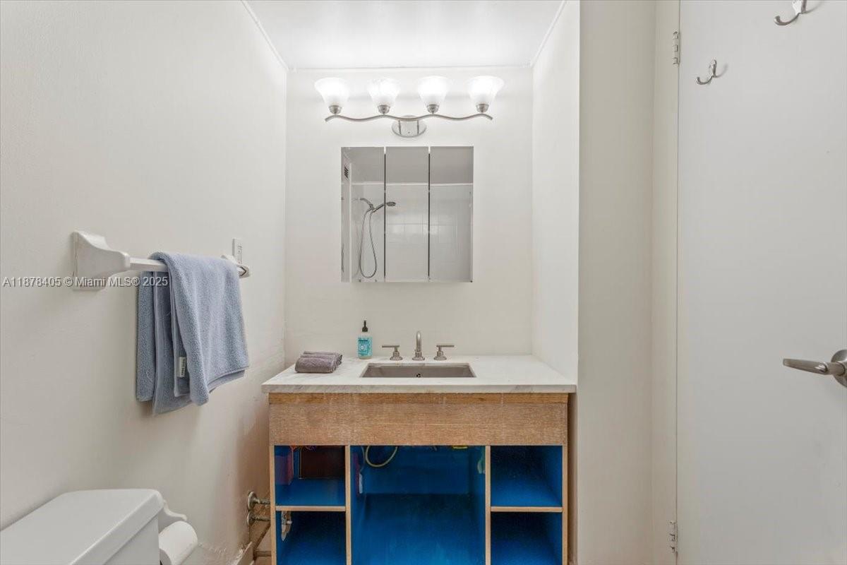 2899 Collins Avenue, Unit 1104 Miami Beach, FL 33140 - Photo 11 of 21 a bathroom with a sink a mirror and a toilet