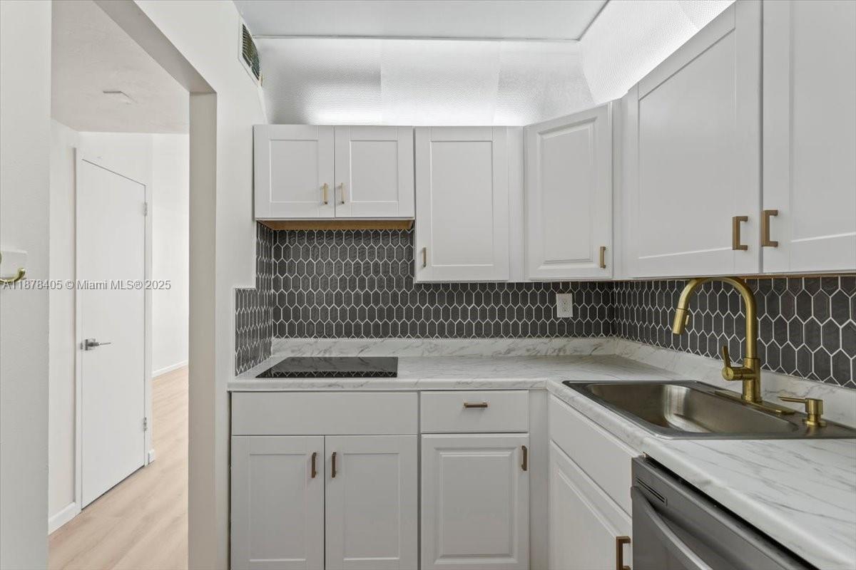2899 Collins Avenue, Unit 1104 Miami Beach, FL 33140 - Photo 7 of 21 a kitchen with a sink and cabinets