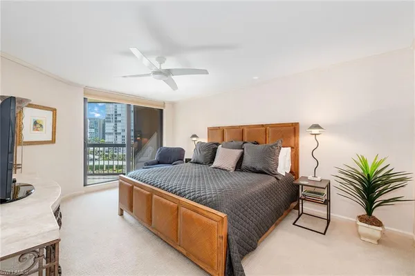 a spacious bedroom with a bed and a flat screen tv