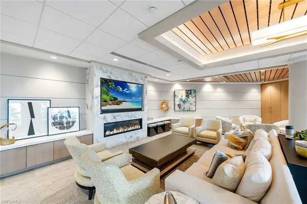 a living room with furniture a flat screen tv and a floor to ceiling window