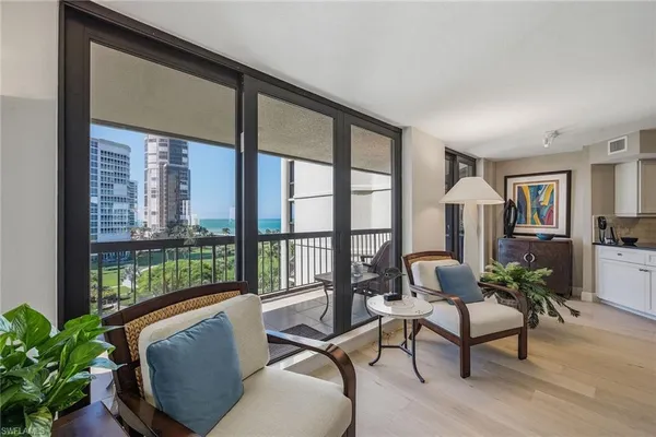 a living room with furniture and a floor to ceiling window