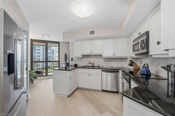 a kitchen with stainless steel appliances granite countertop a stove refrigerator and cabinets