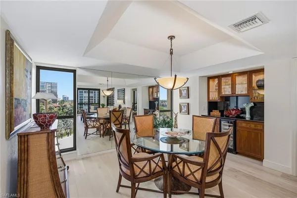 a view of a dining room and livingroom with furniture wooden floor a chandelier