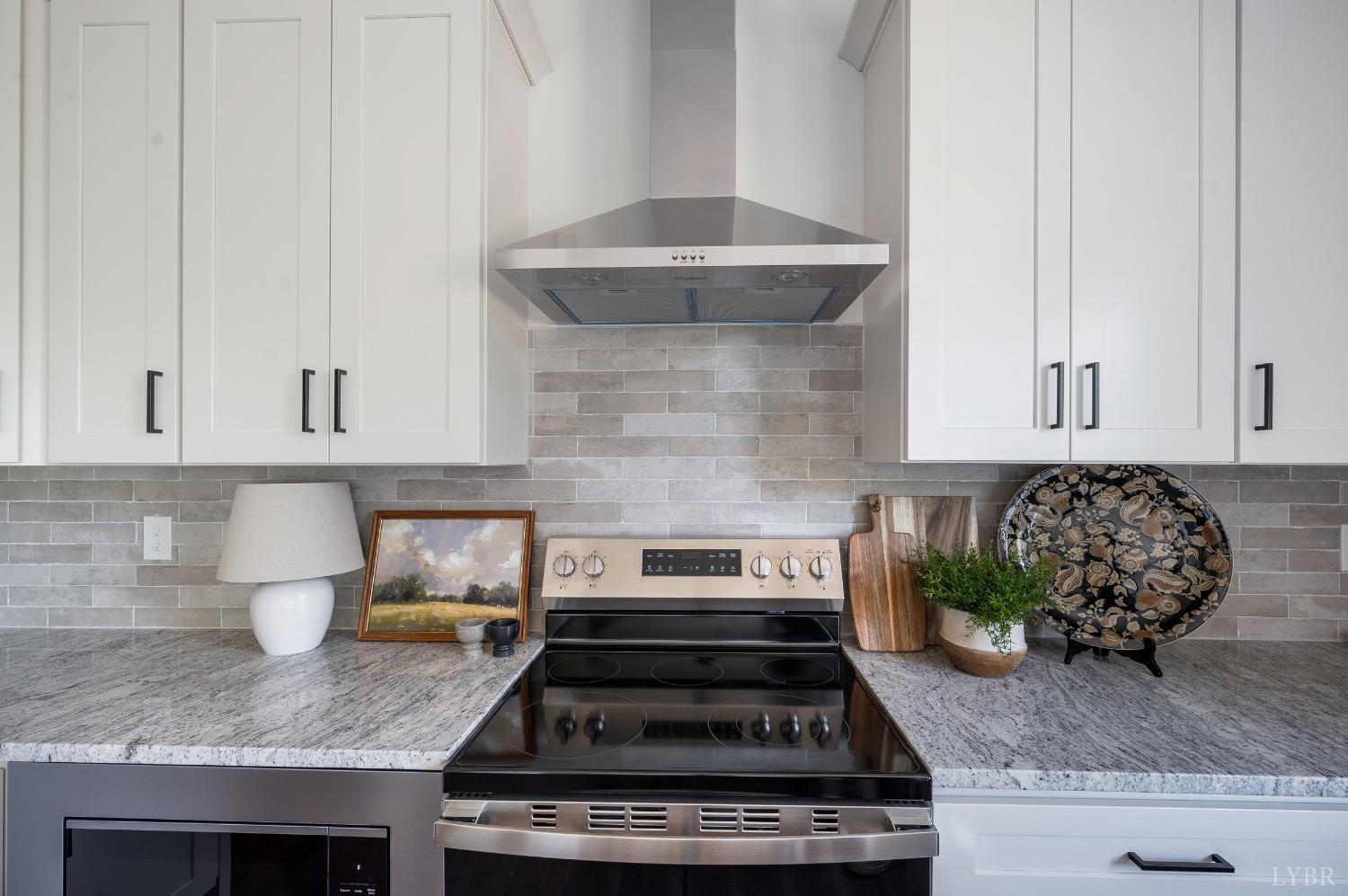 4424 Goode Road Goode, VA 24556 - Photo 24 of 71 a kitchen with granite countertop a stove top oven a sink and cabinets