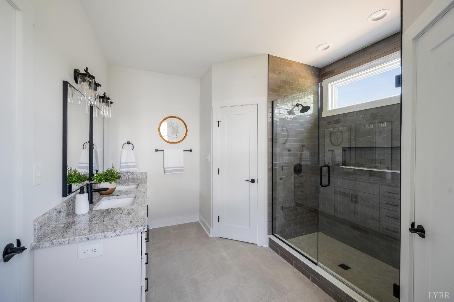 4424 Goode Road Goode, VA 24556 - Photo 34 of 71 a bathroom with a granite countertop sink a mirror and shower