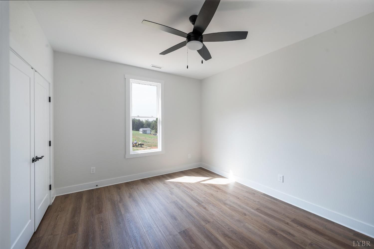 4424 Goode Road Goode, VA 24556 - Photo 49 of 71 an empty room with wooden floor ceiling fan and windows