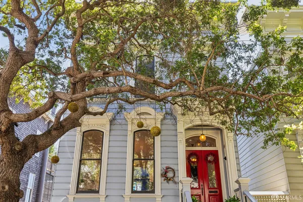 a front view of a house with a tree