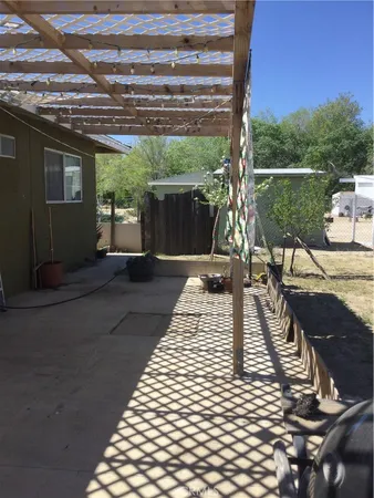 a view of a patio with table and chairs with wooden floor and fence