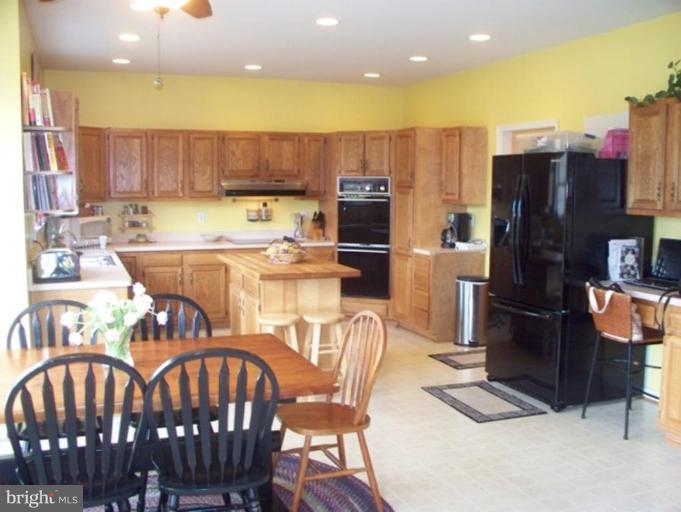 3185 Jones Road Dunkirk, MD 20754 - Photo 14 of 28 a kitchen with stainless steel appliances wooden floor dining table and chairs