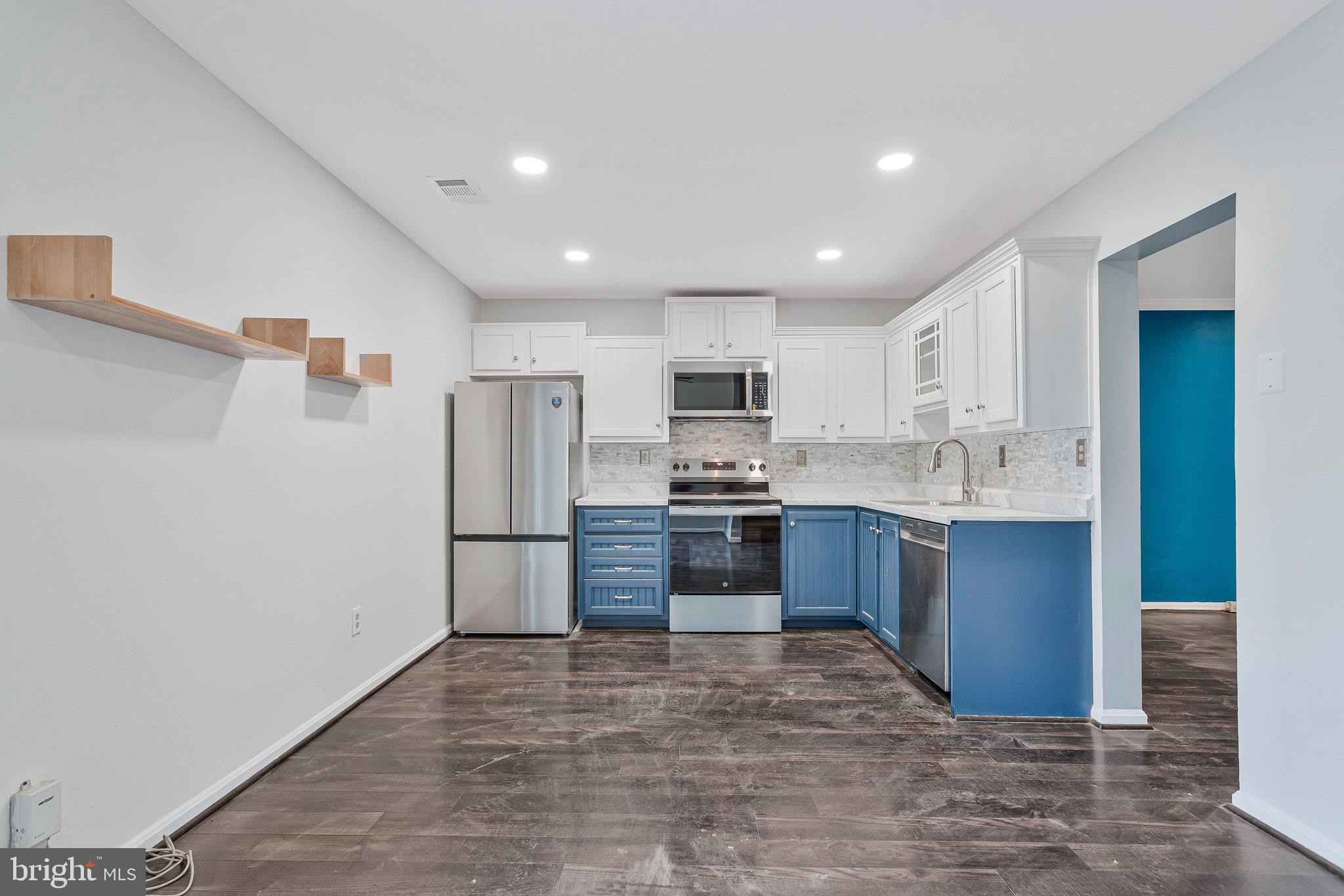 1675 Ridgely Court, Unit 182 Crofton, MD 21114 - Photo 25 of 47 a large kitchen with a refrigerator and white cabinets