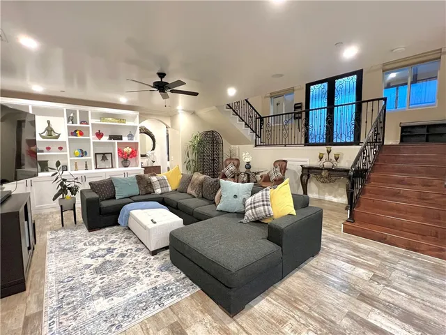 a living room with furniture a ceiling fan and a rug