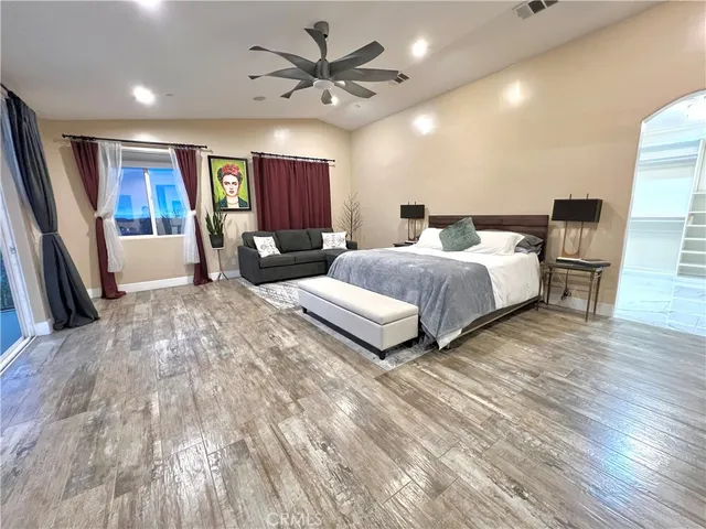 a spacious bedroom with a bed a couch and a chandelier