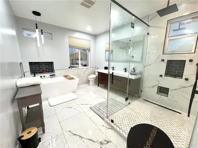 a large white kitchen with a stove a sink dishwasher and a fireplace with wooden floor