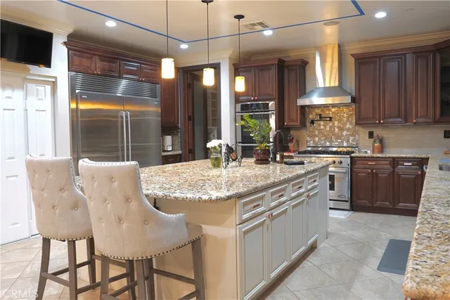a kitchen with kitchen island granite countertop a table chairs sink and cabinets