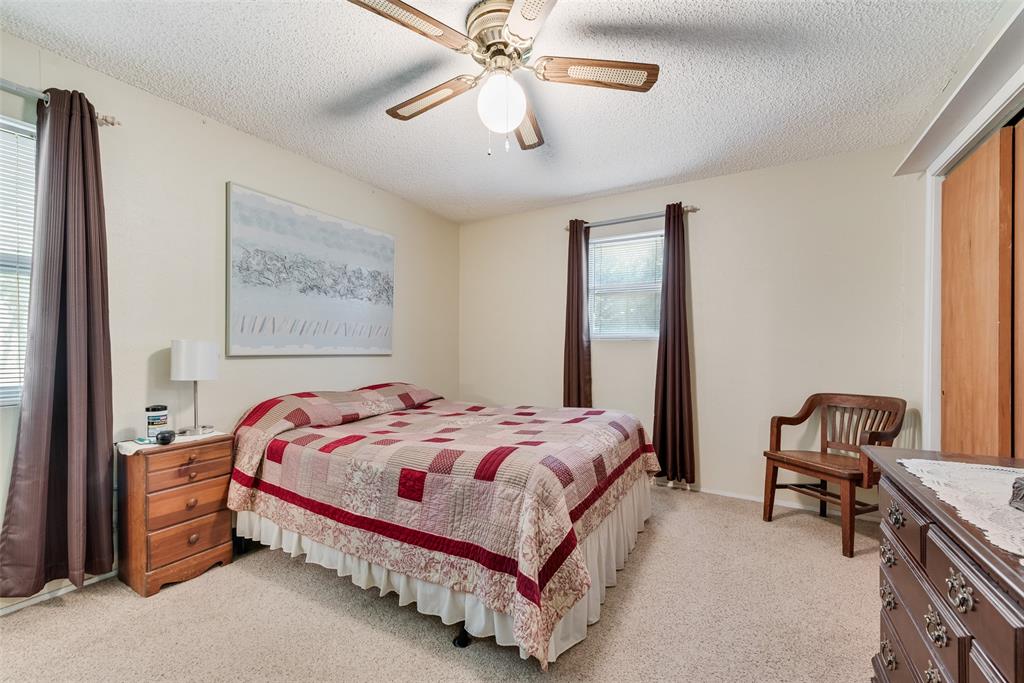 646 Liska Road Ennis, TX 75119 - Photo 15 of 23 a bedroom with a bed and a chandelier