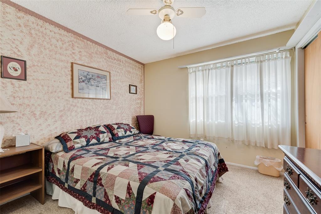 646 Liska Road Ennis, TX 75119 - Photo 18 of 23 a bedroom with a bed and a chandelier