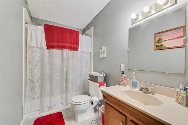a bathroom with a sink vanity mirror and toilet