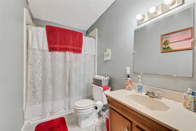 a bathroom with a sink vanity mirror and toilet