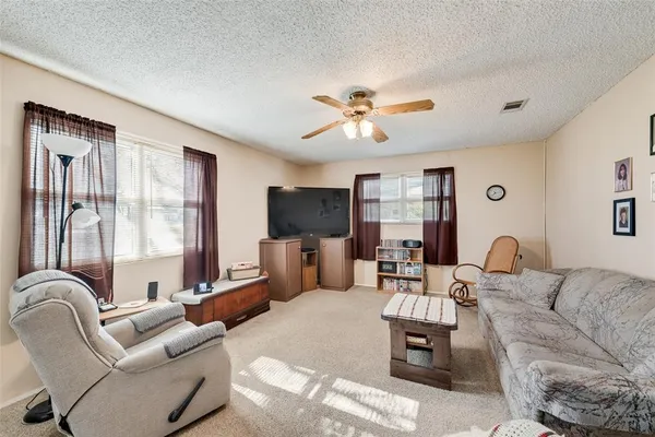 a living room with furniture ceiling fan and a flat screen tv
