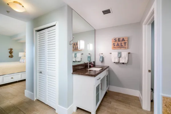 a bathroom with a granite countertop sink toilet mirror and shower