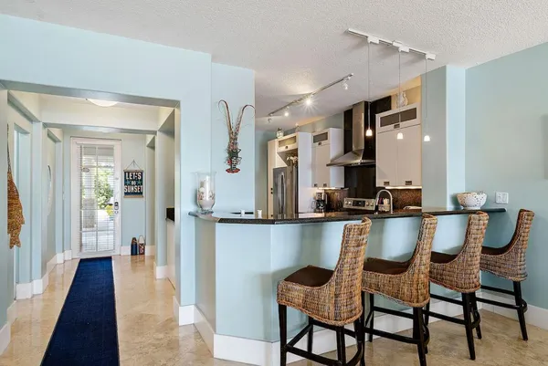 a view of a dining room and livingroom with furniture wooden floor a chandelier