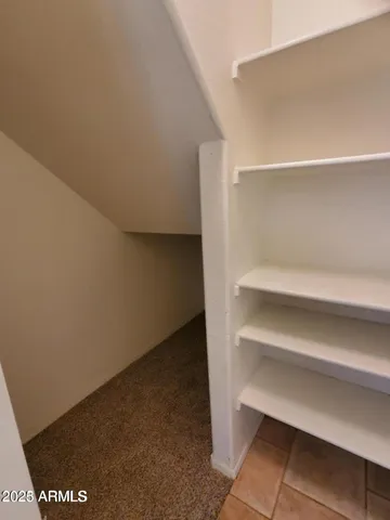 a view of walk in closet with empty racks