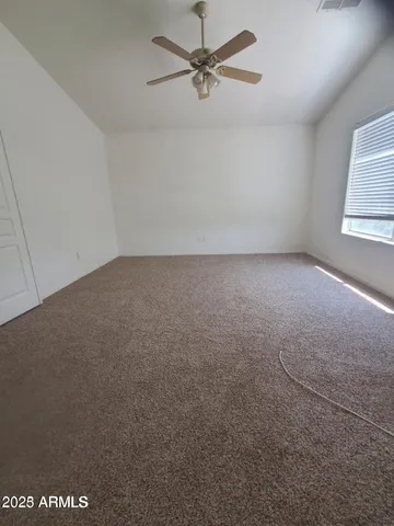 an empty room with windows and fan