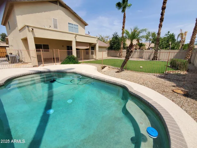 a swimming pool with outdoor seating and yard