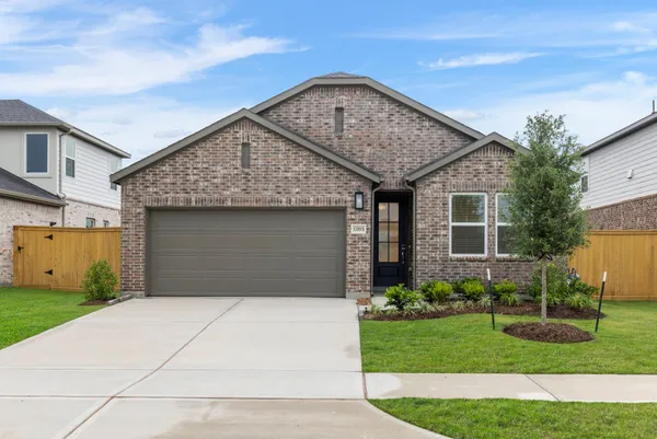 a front view of a house with a garden and garage