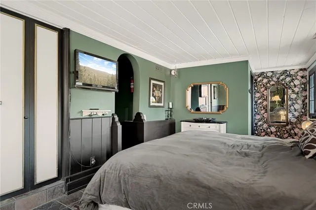 a bedroom with a large bed and a tv