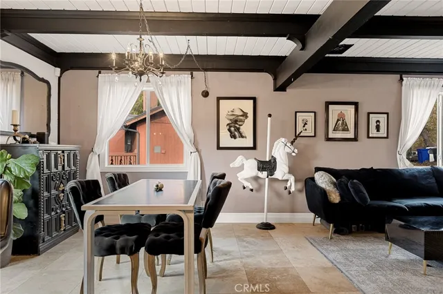 a living room with furniture a dining table and a chandelier