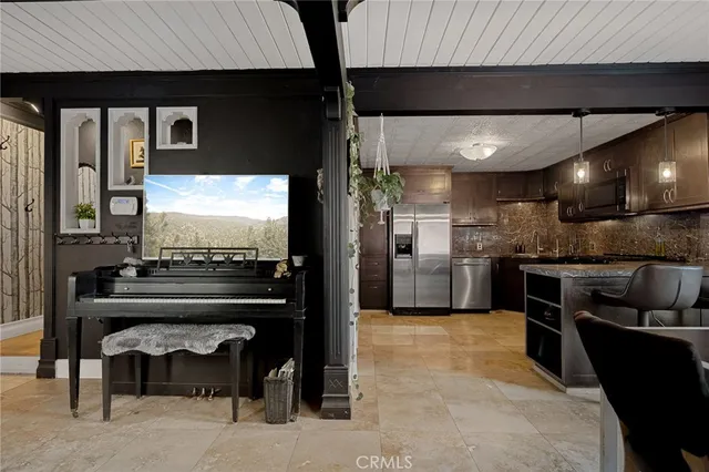 a kitchen with stainless steel appliances kitchen island granite countertop a refrigerator and a stove