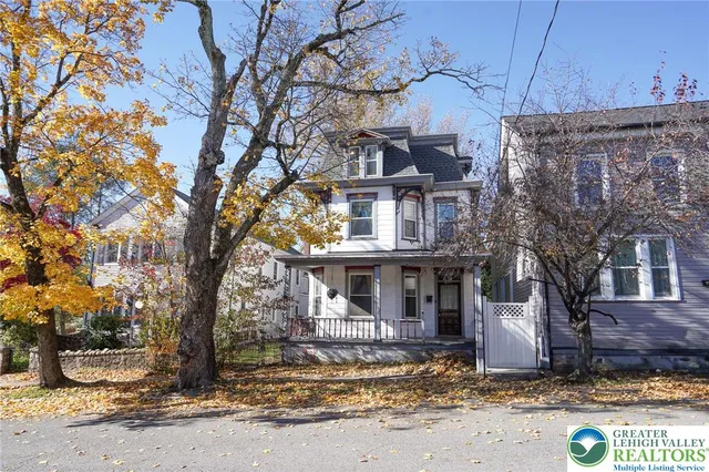 a street sign on a blue house next to a road